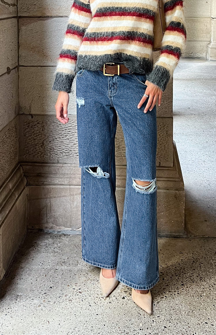 Mid wash ripped jeans with wide legs and large rips at both knees