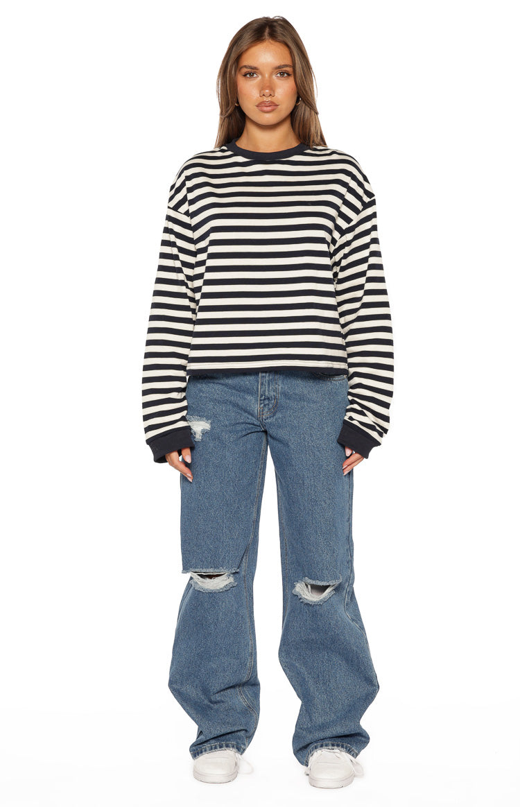 Front view of mid wash blue wide-leg ripped jeans with large rips at both knees