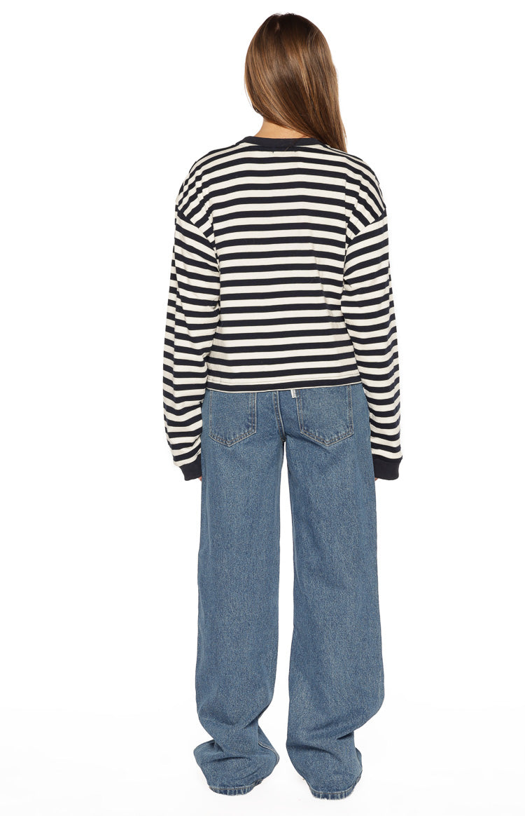 Rear view of mid wash jeans with classic back patch pockets and a relaxed wide-leg fit