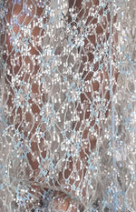 Close-up of the blue floral lace pattern with small silver sequins on the sheer maxi skirt