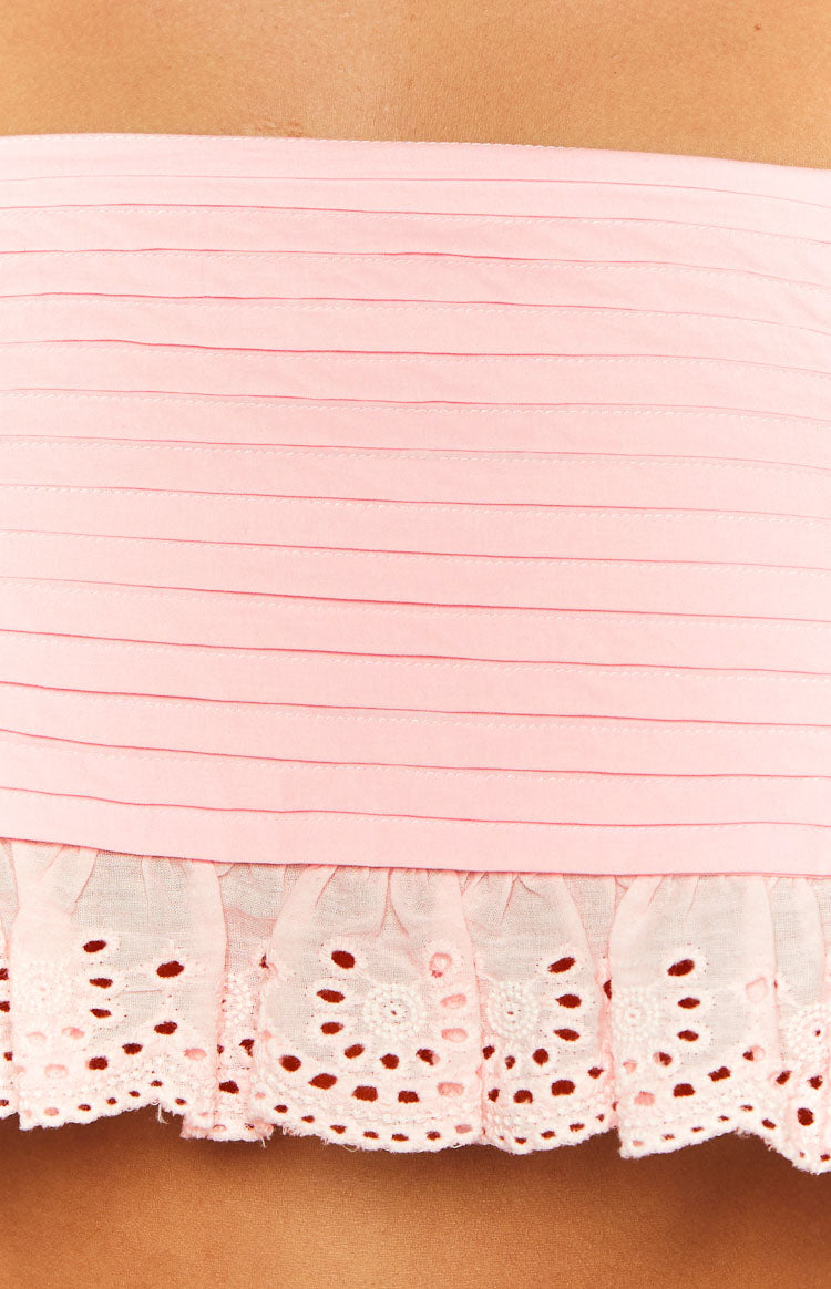 Close-up of the pink crop top's pintucked bodice and ruffled broderie anglaise hem