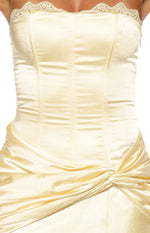 Close-up of the yellow satin strapless bodice with lace trim, corset seaming, and ruched twist waist detail