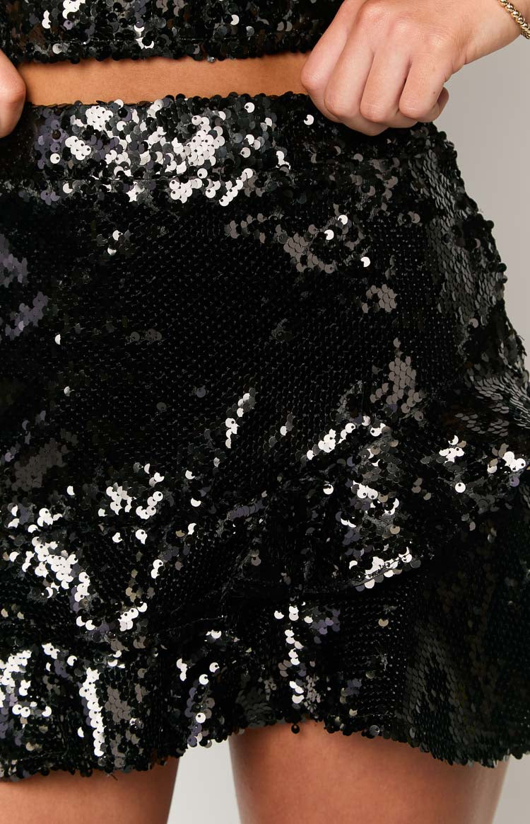 Close-up of the black sequin fabric on the mini skirt, showing the shimmering texture and gathered detail