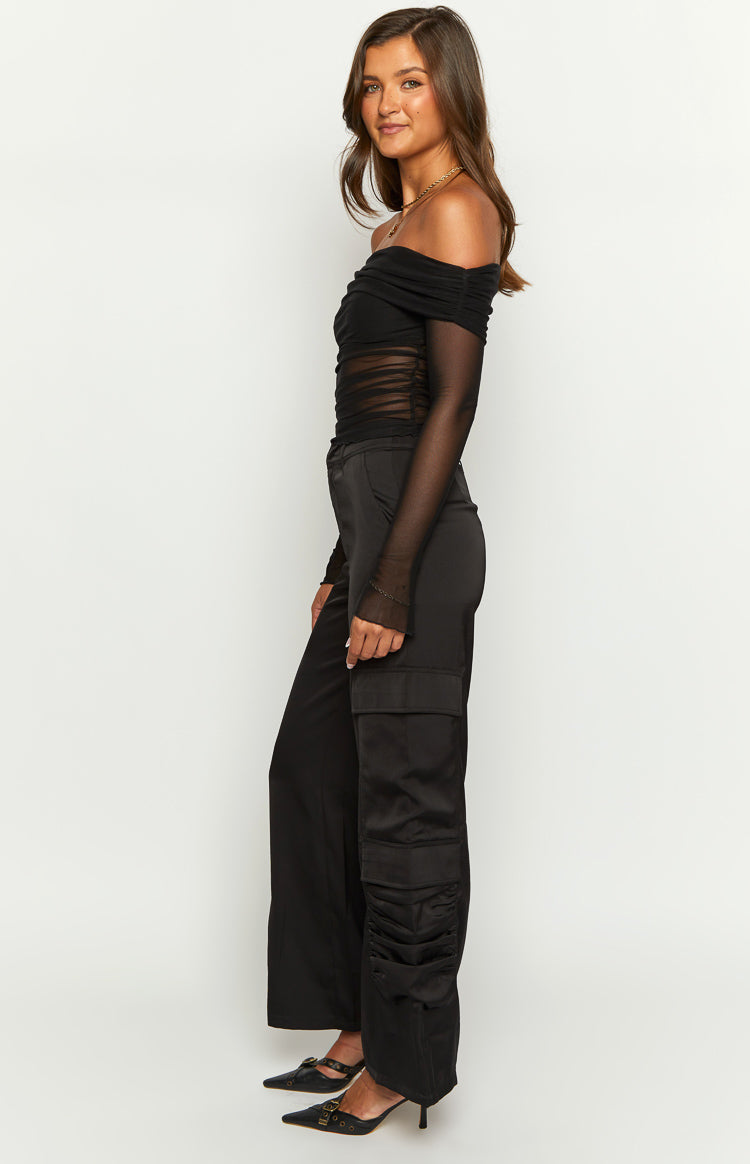 Side view of black satin cargo pants with a wide leg and ruched detail below the side pocket