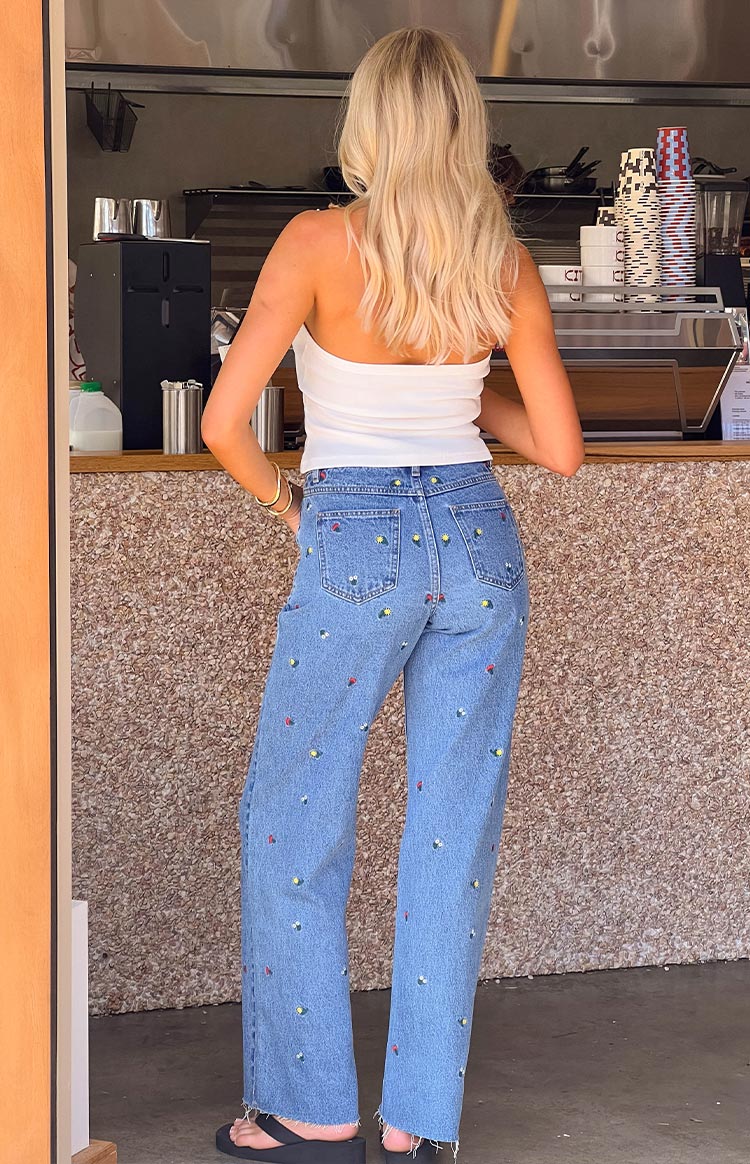 Rear view of a white fitted halter neck top with a straight back and smooth knit fabric