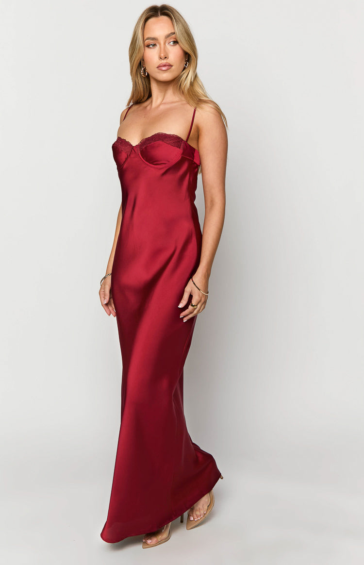 Angled view of a red satin maxi dress with a lace-trimmed sweetheart neckline and a flowing skirt