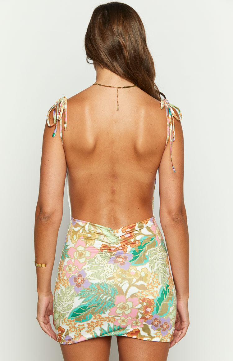 Rear view of a tropical print mini dress featuring a low scoop back, ruched waist, and shoulder ties