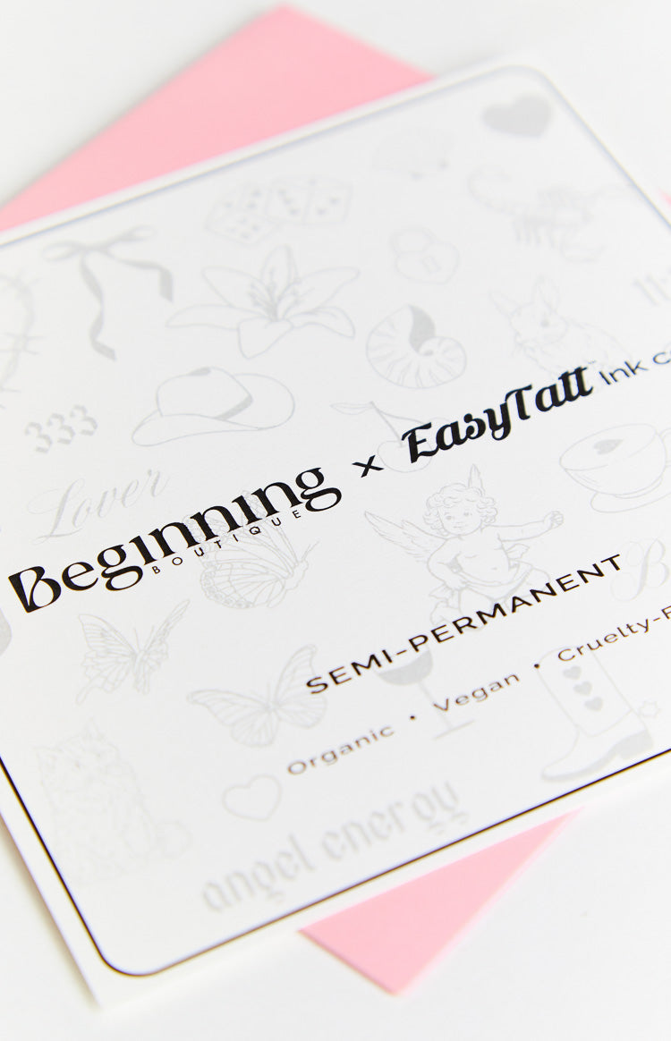 White sheet of semi-permanent tattoos featuring light grey butterflies, cowboy hats, cherubs, and text Organic Vegan