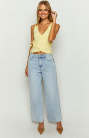 Front view of light wash denim wide leg boyfriend jeans with a high waist and raw frayed hem
