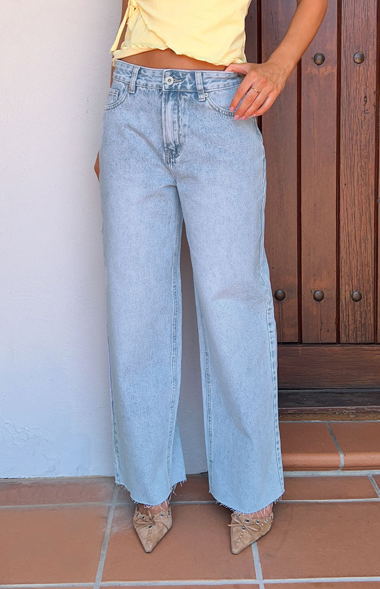 Light wash wide leg boyfriend jeans with a high waist and frayed raw hem