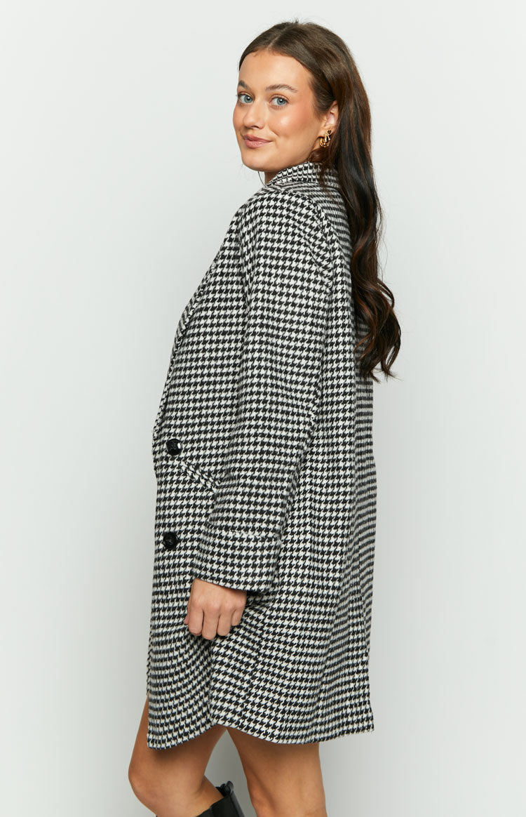 Side view of an oversized black and white houndstooth check jacket with black buttons