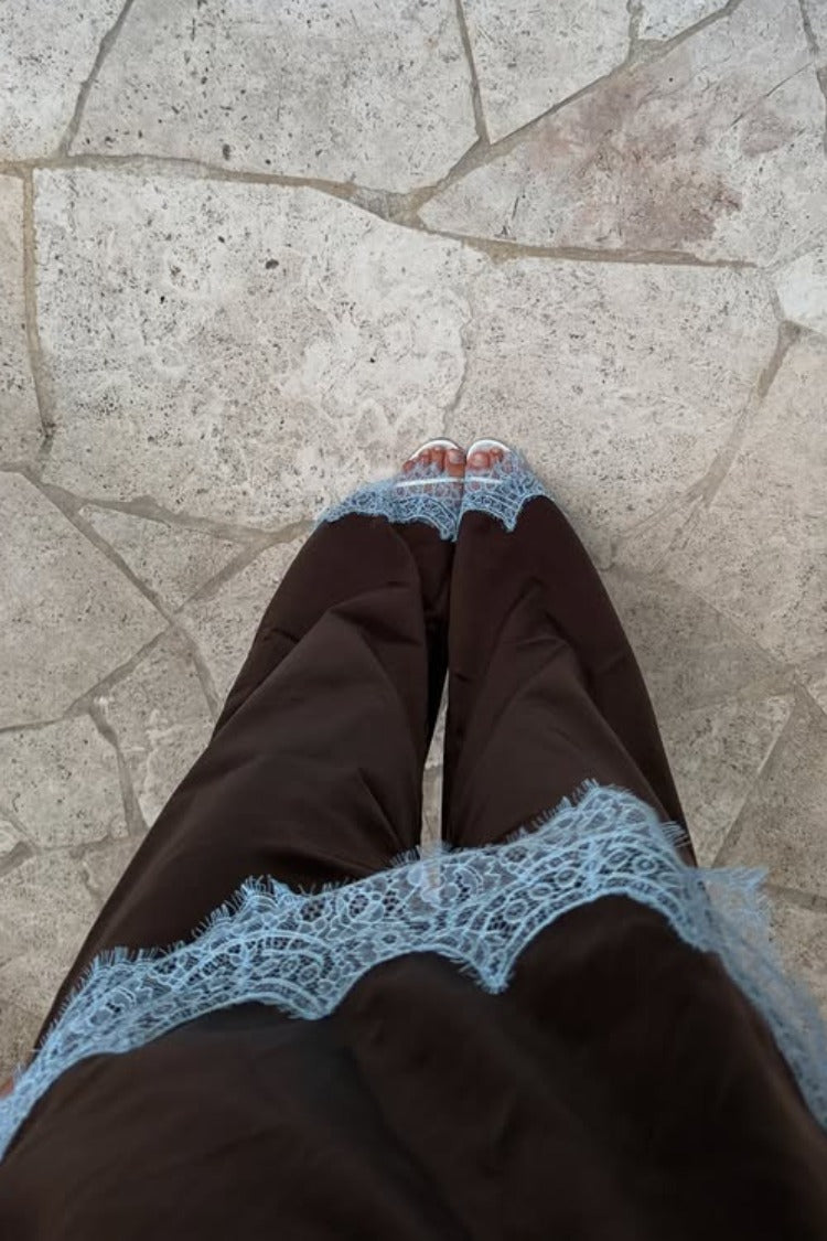 Top-down view of a brown satin top featuring wide light blue lace trim along the bottom hem
