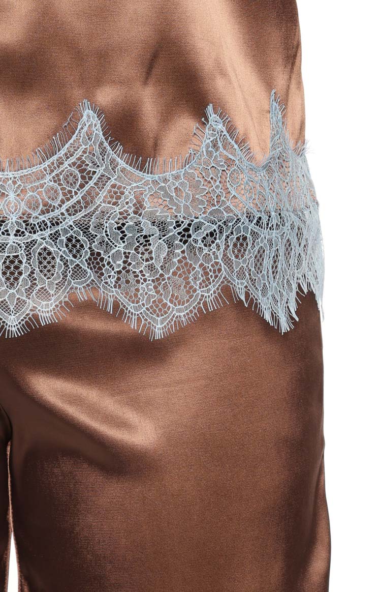 Close-up of the intricate light blue scalloped lace trim on the brown satin strapless top