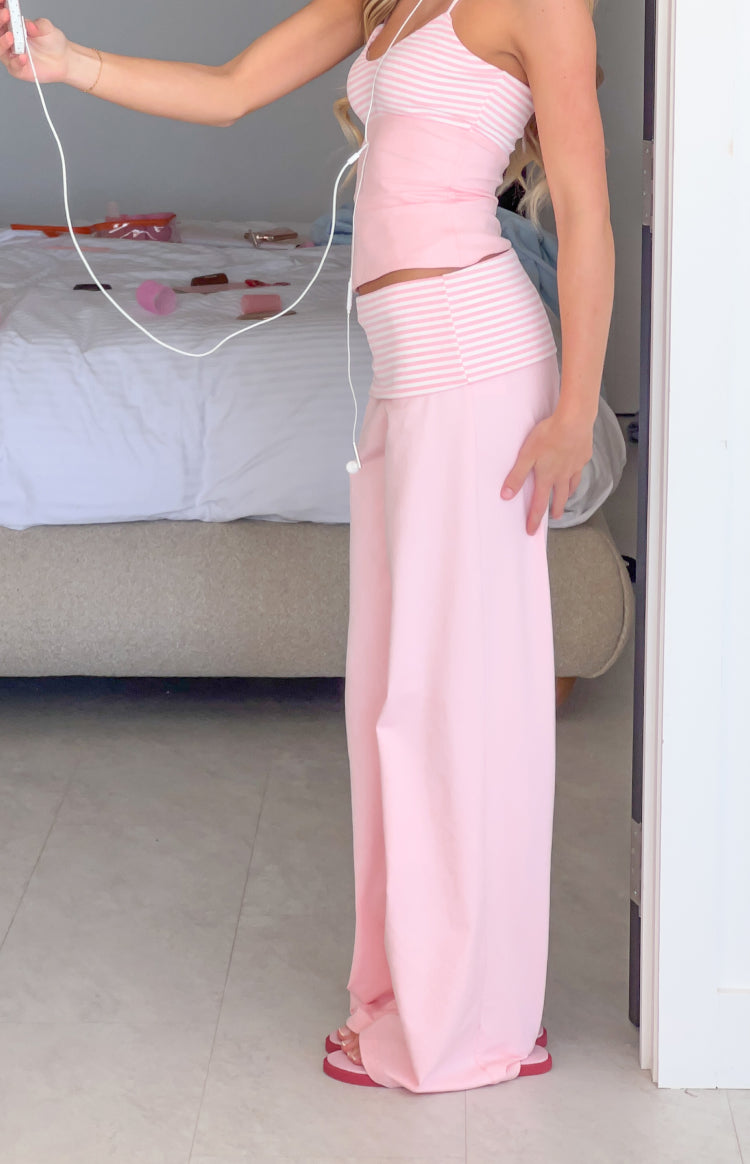 Side view of light pink jersey pants with a wide leg and a striped foldover waistband