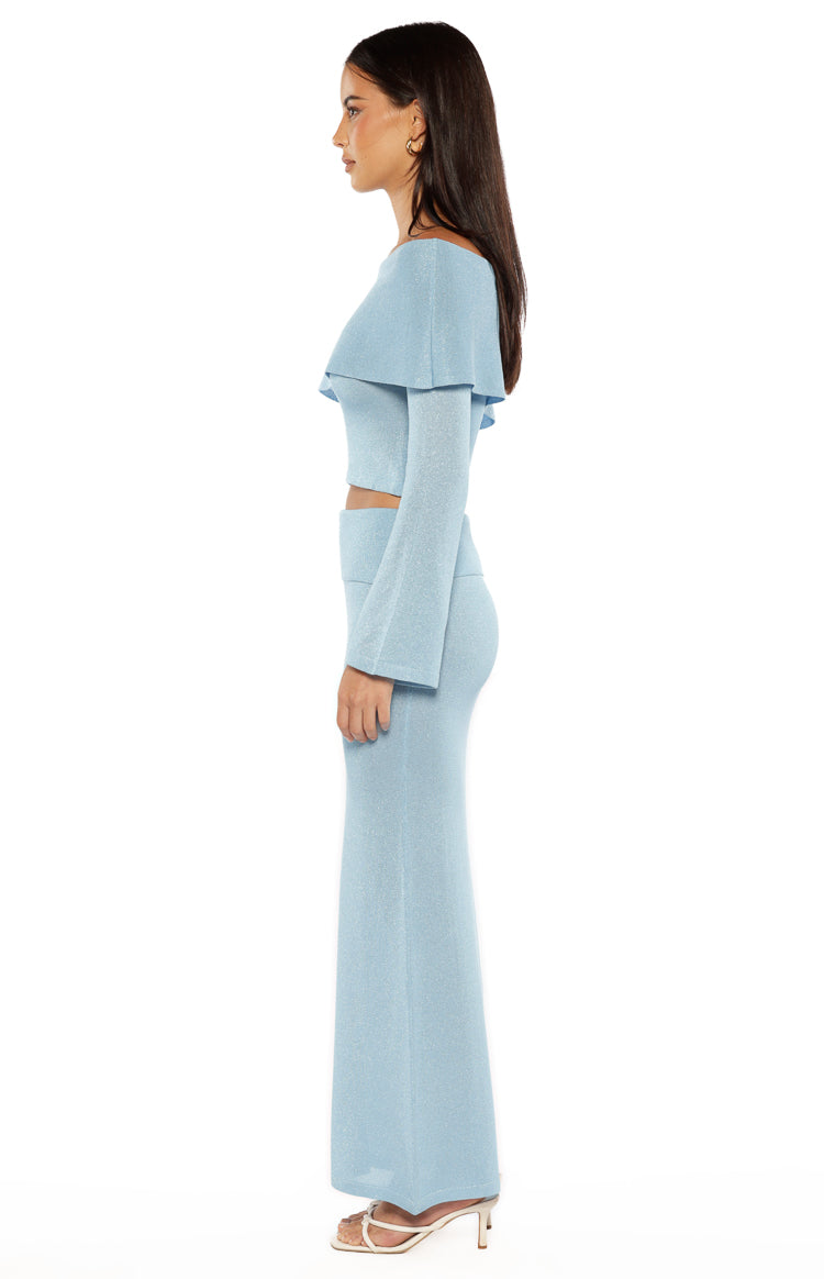 Side view of the blue shimmery knit maxi skirt, highlighting the fitted silhouette and subtle flare
