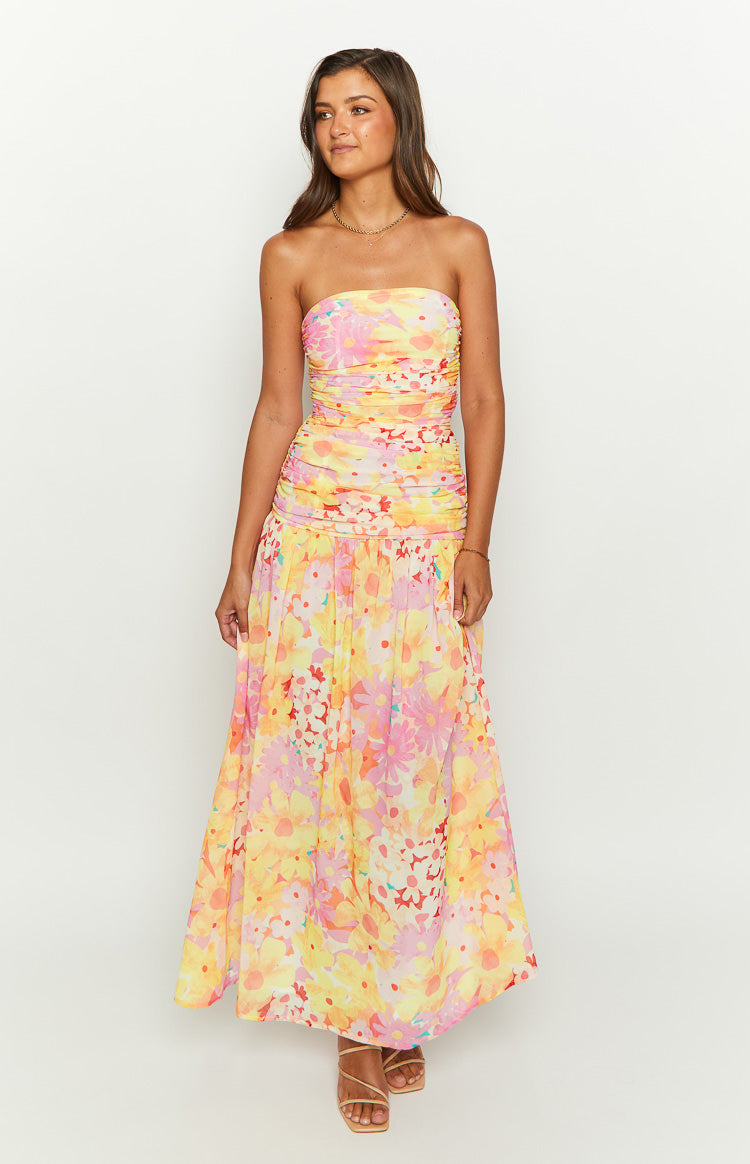 Front view of a yellow floral print strapless maxi dress featuring a ruched, fitted bodice and a flowing skirt