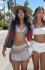 White zebra print low-rise mini skirt with a wrap-style front, festival look