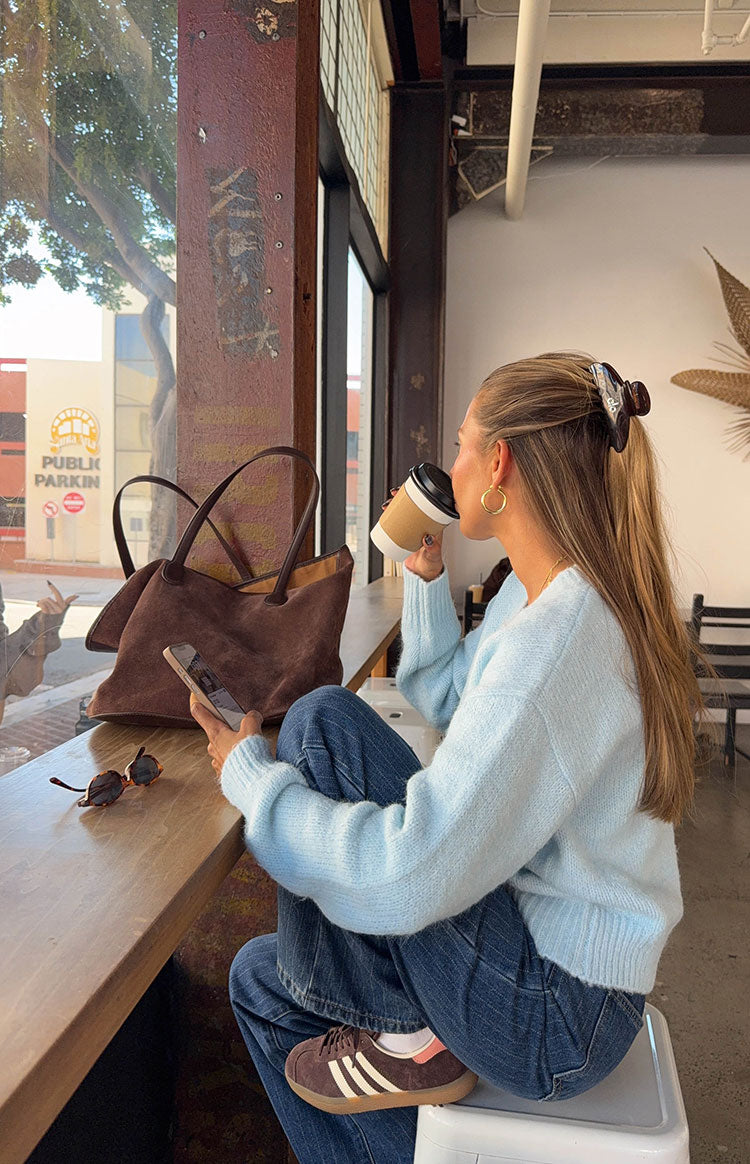 Side view of the light blue fuzzy knit cardigan with ribbed cuffs and hem