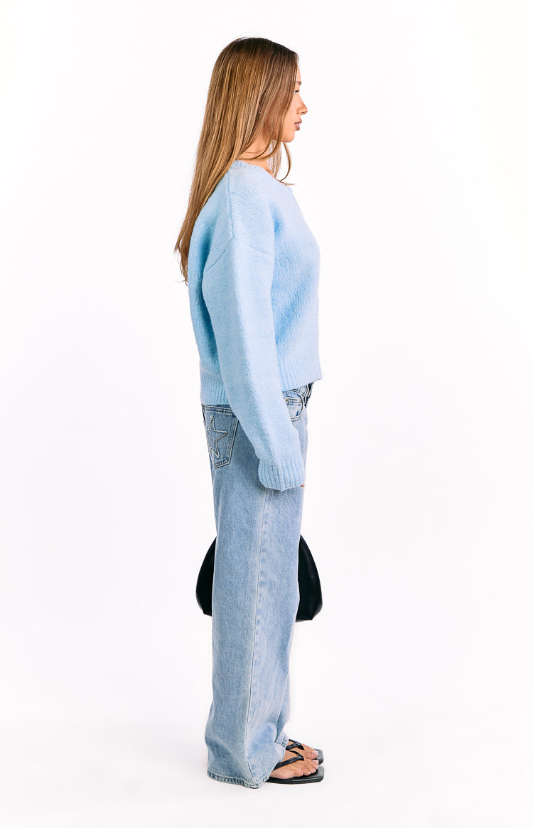 Side view of a light blue fuzzy knit cardigan showing its relaxed cropped fit and long sleeves