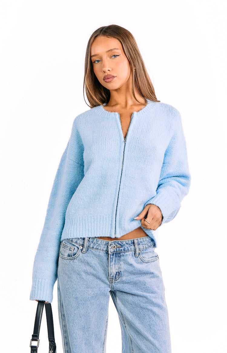 Front view of a light blue fuzzy knit cardigan with a silver zip closure and round neckline