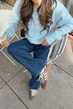 Front view of a light blue fuzzy knit cardigan with a full front zipper and ribbed cuffs