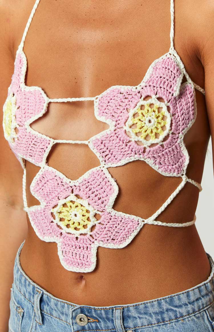 Close-up of the pink crochet halter top with yellow floral centers and white open-knit string details