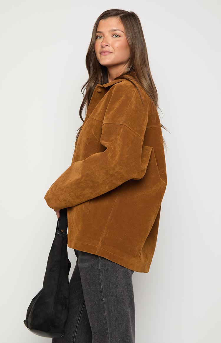 Side view of a tan suede oversized jacket with long sleeves and a relaxed fit