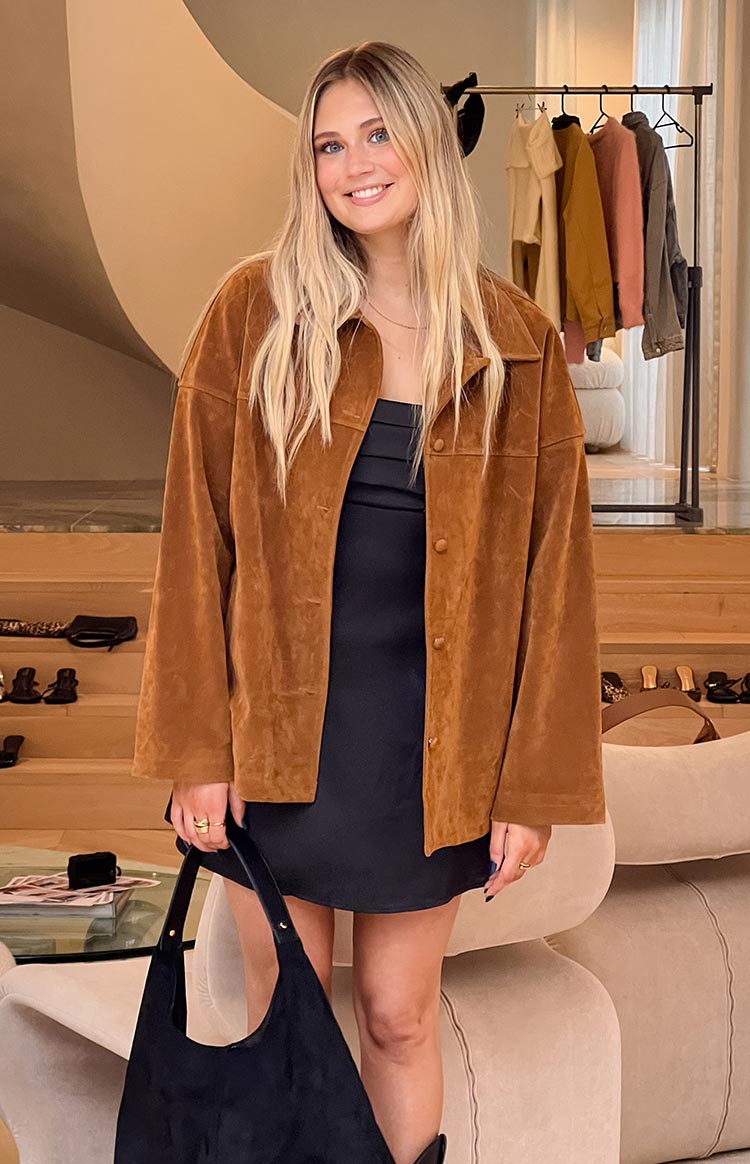 Front view of a tan suede oversized jacket with a collared neckline and long sleeves, worn open