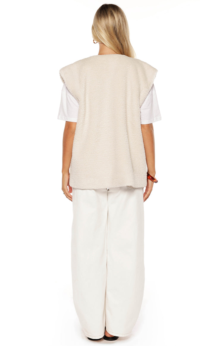 Rear view of the cream teddy fleece vest, showing the plush texture and wide cap sleeves