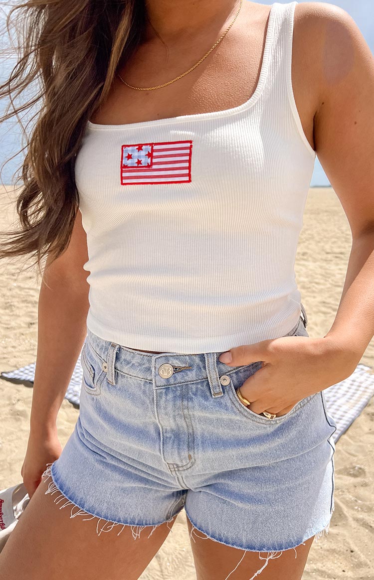 Close-up of the white ribbed tank top with square neckline and USA flag embroidery