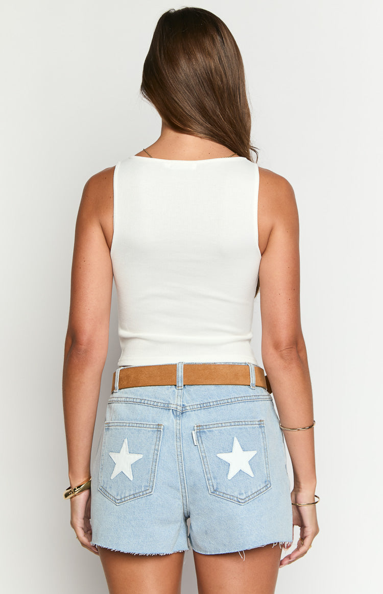 Rear view of a fitted white ribbed tank top showing the high back neckline and sleeveless design