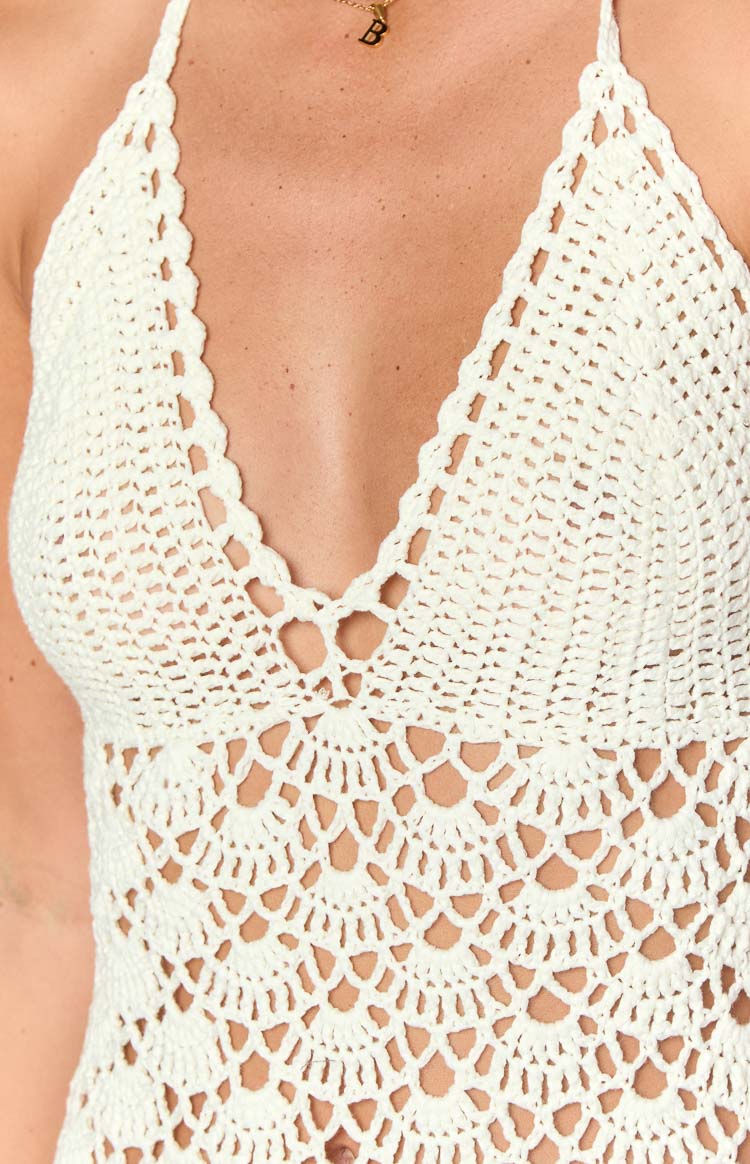 Close-up of the white crochet deep V-neckline with scalloped edges and intricate circular patterns on the bodice