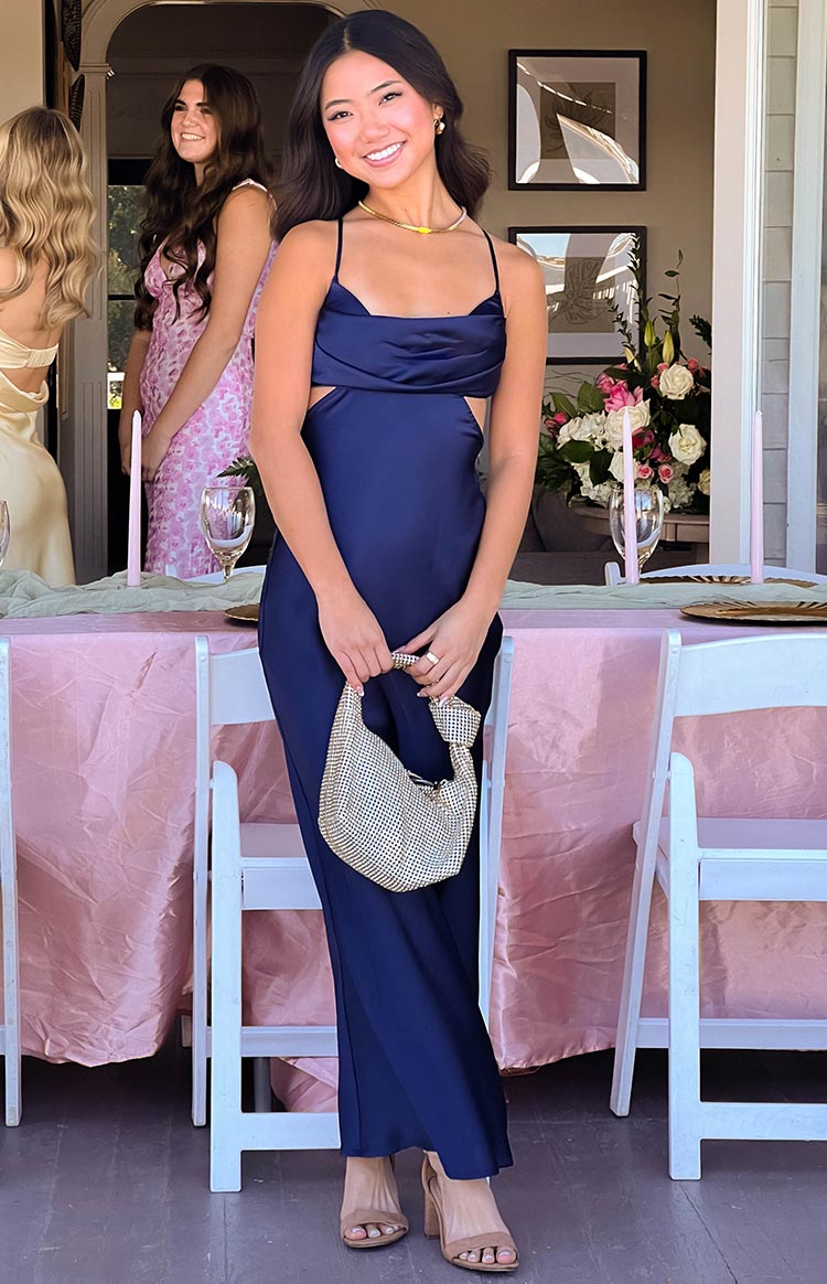 Fitted navy formal maxi dress featuring a draped cowl neck and prominent side waist cutouts