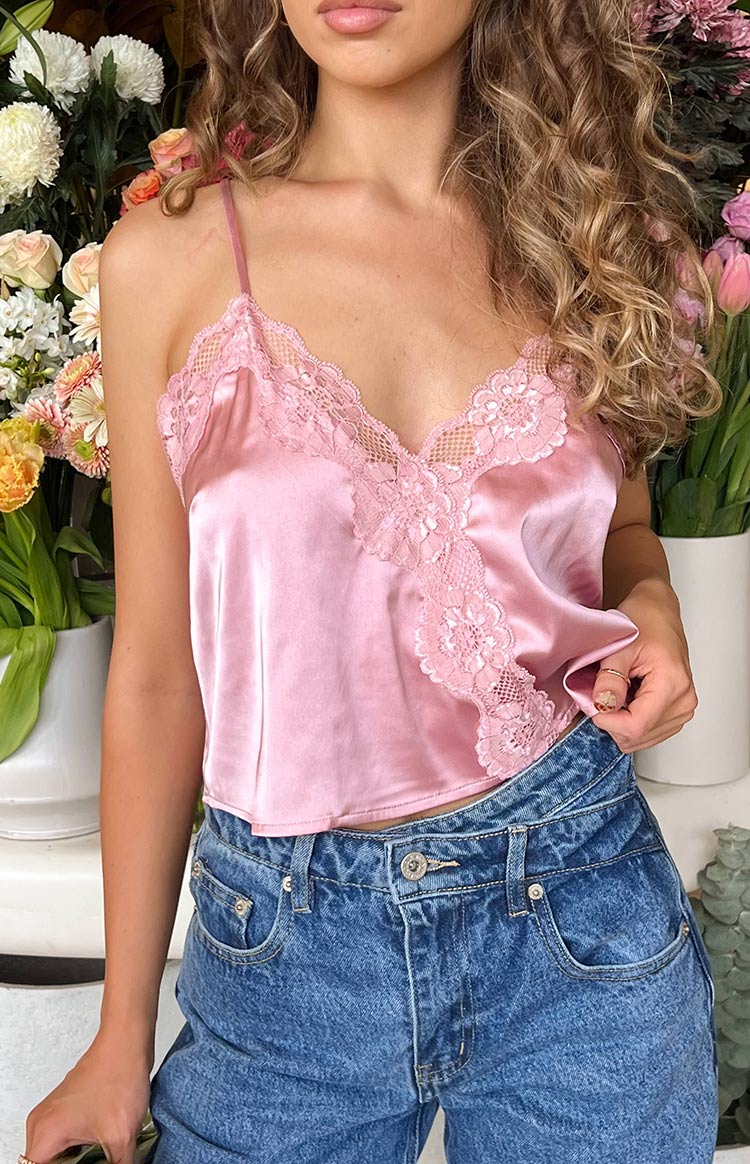 Front close-up of the pink satin cami top, highlighting the delicate floral lace V-neckline and spaghetti straps