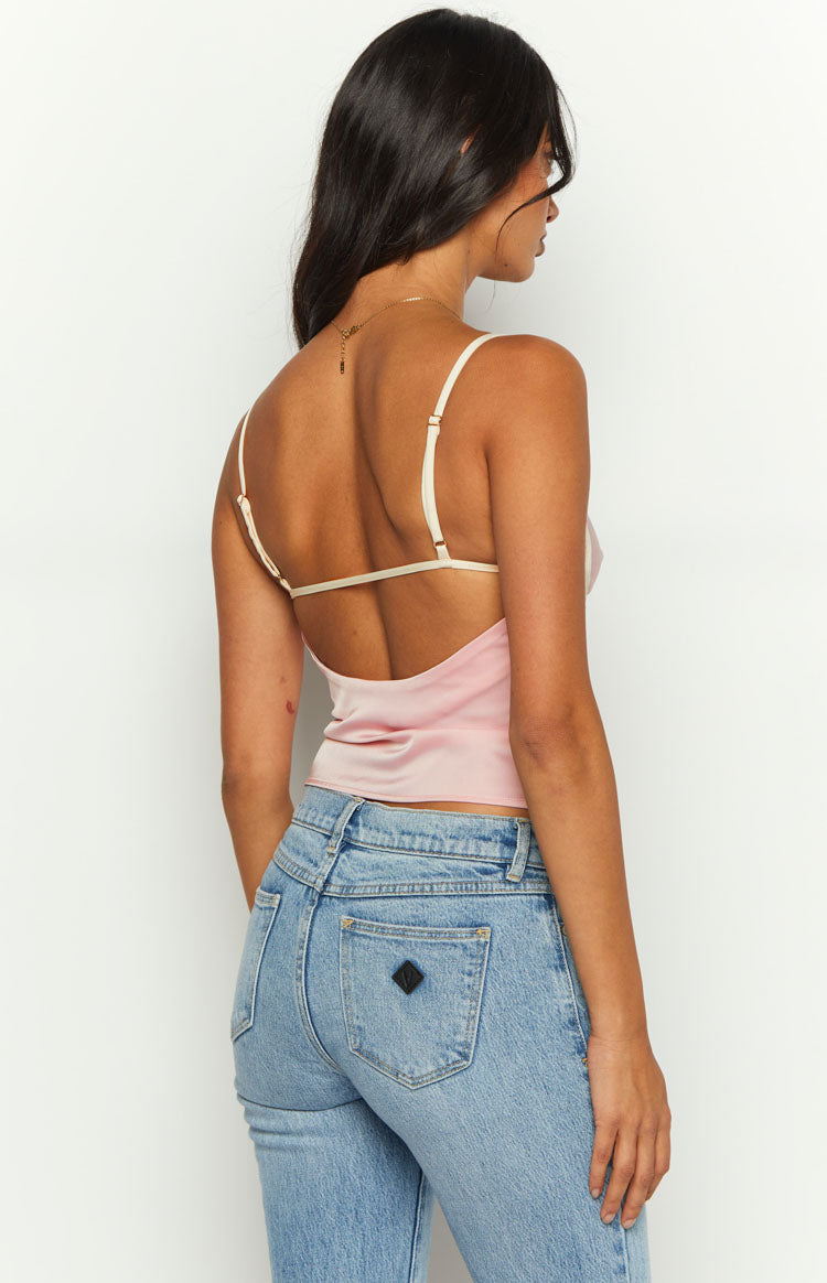 Rear view of a pink satin low back top with thin adjustable cream straps and a horizontal back strap