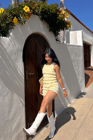 Profile view of bright yellow textured shorts with a high-rise waist and short hem