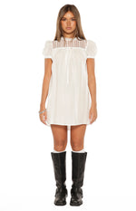 Front view of a white sheer mini dress with a high lace panel neckline and short puff sleeves