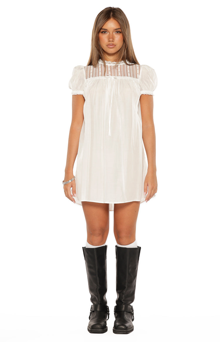 Front view of a white sheer mini dress with a high lace panel neckline and short puff sleeves