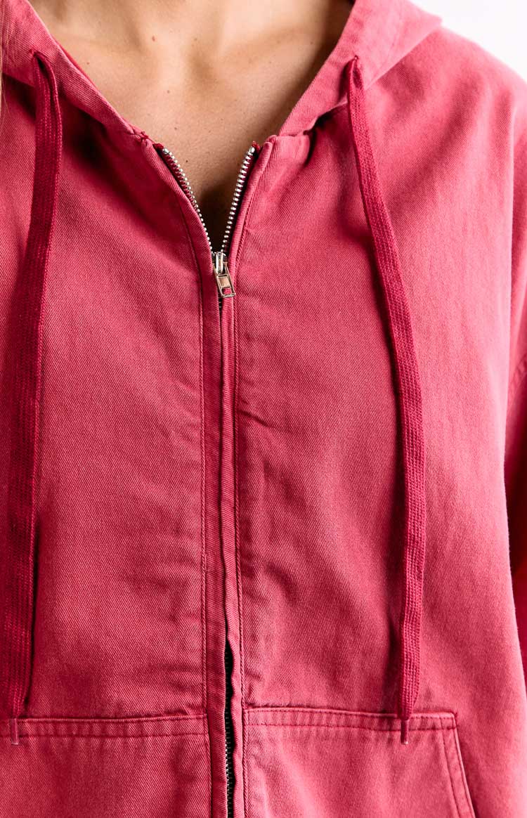 Close-up of the silver zipper and matching red drawstring on a washed red hooded jacket