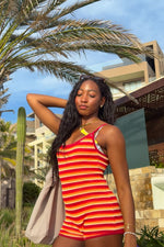 Bodycon orange, red, and white horizontal stripe knit playsuit with a scoop neckline and thin spaghetti straps