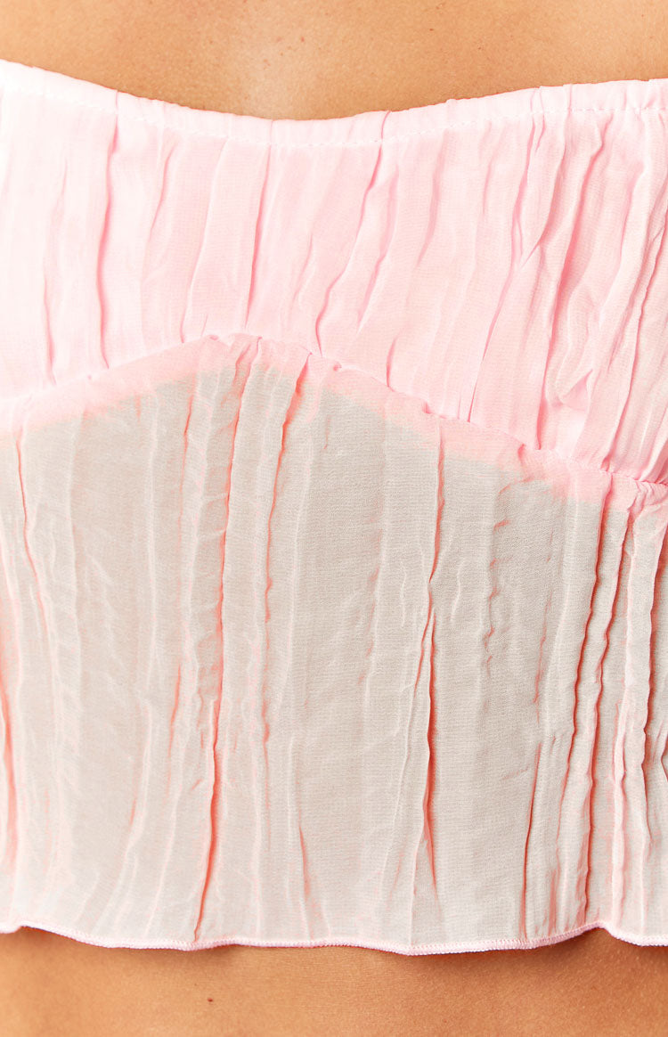Close-up of the ruched pink fabric texture and the V-shaped bust line of the cami top
