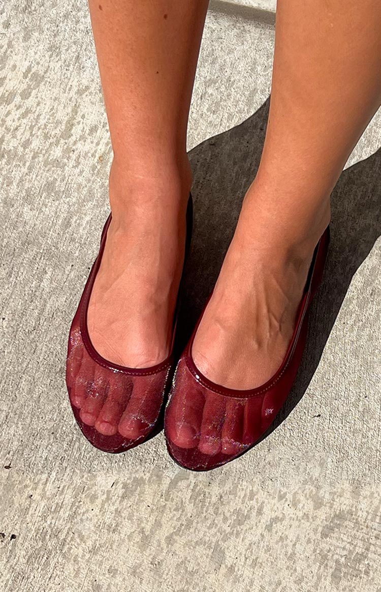 Cherry red patent ballet flats with transparent mesh toe boxes and a glossy finish