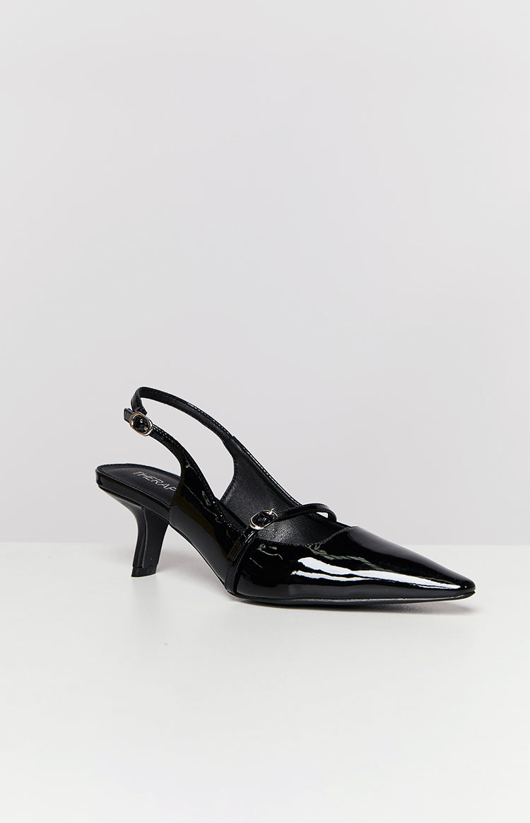 Side view of a black patent slingback heel with a pointed toe, low kitten heel, and Mary Jane strap