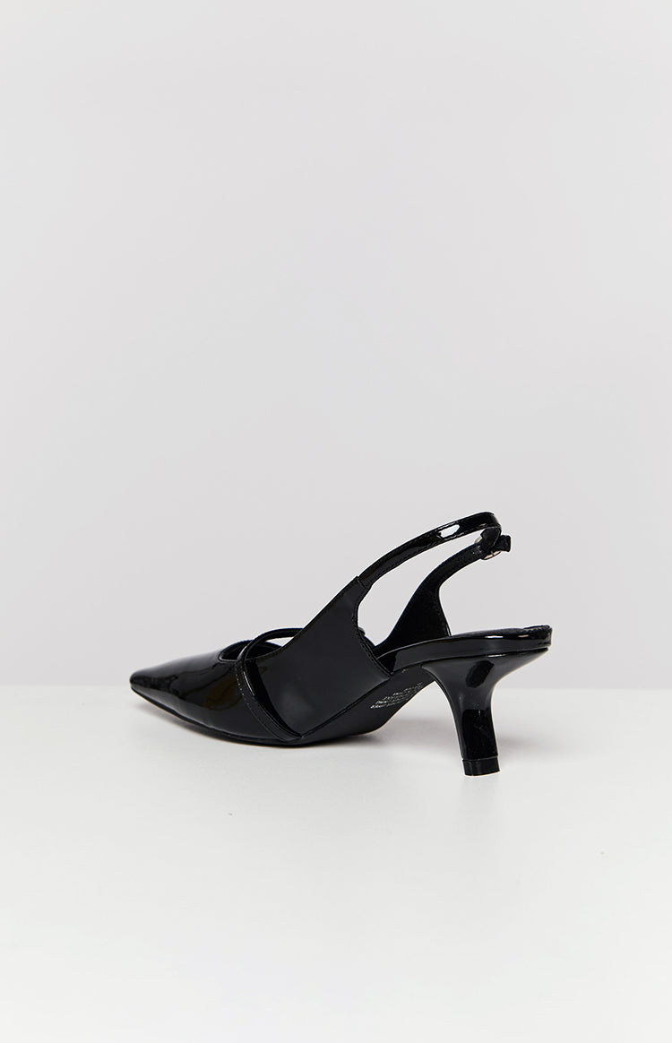 Side view showing the adjustable slingback strap and low kitten heel of a black patent shoe
