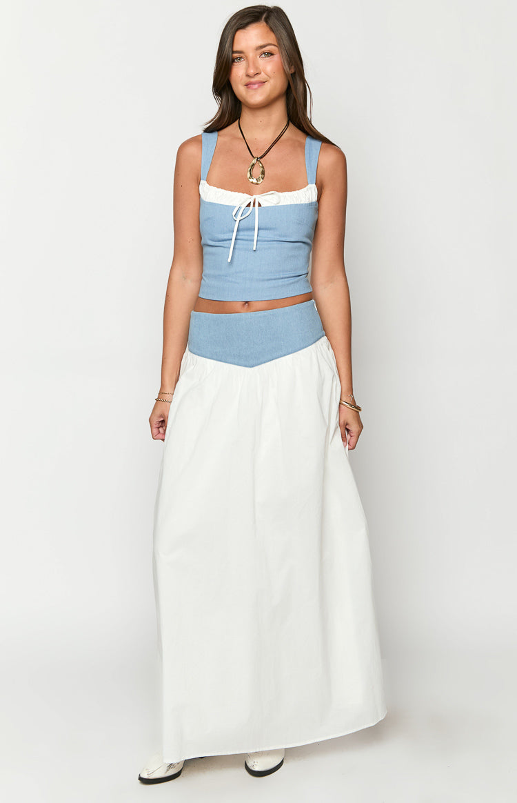 Front view of a mid wash denim crop top with a square neckline, white ruffle trim, and white tie-front detail