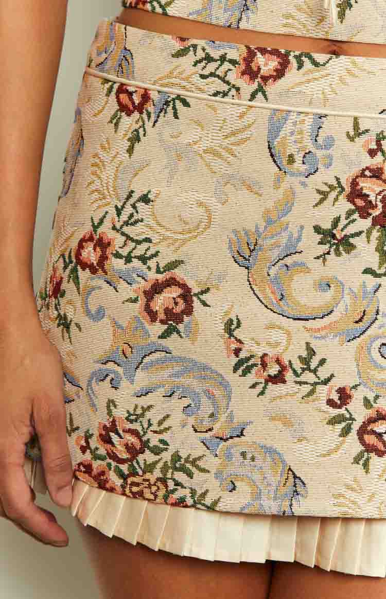 Close-up of the beige pleated trim detail at the hem of the tapestry skirt