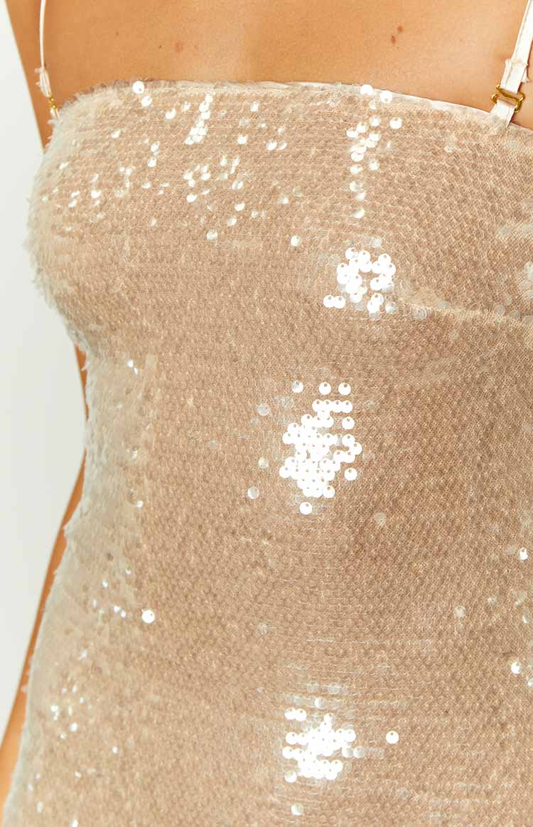 Close-up of the shimmering gold sequin fabric of the mini dress, showing small round sequins