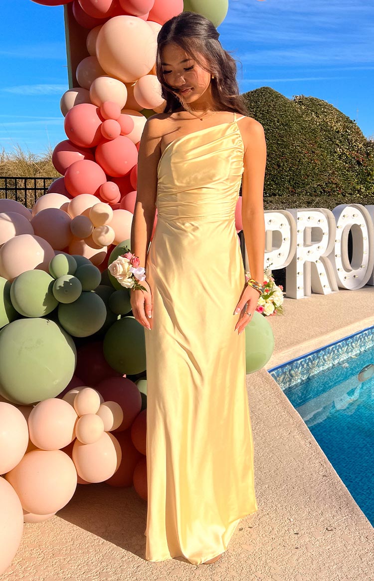 Yellow one-shoulder formal maxi dress with a ruched bodice and a flowy satin skirt