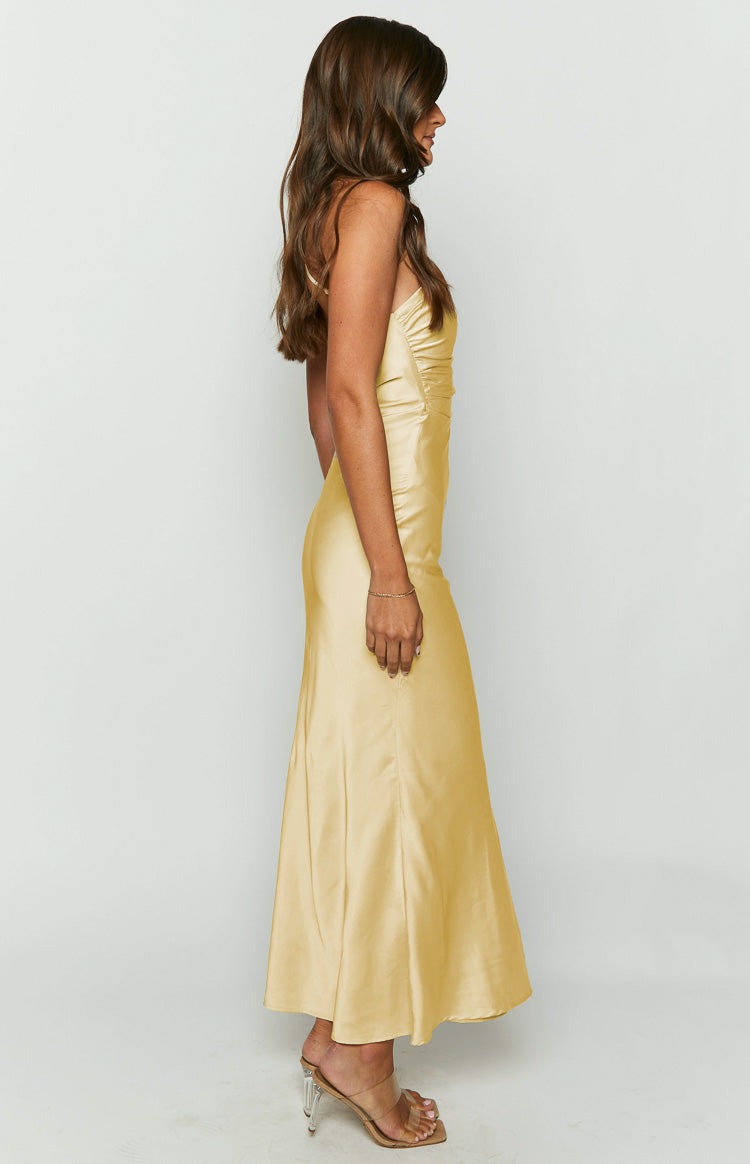 Side view of a yellow satin maxi dress with spaghetti straps and ruched detailing on the side bodice