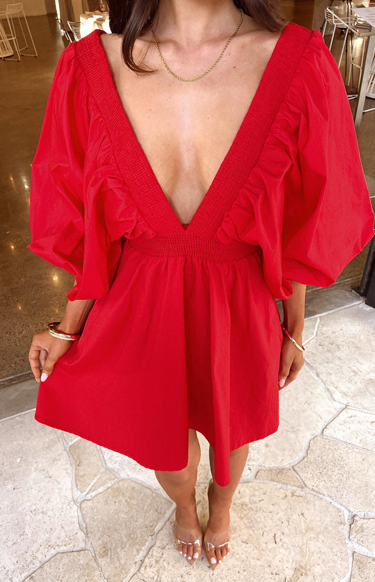Top-down view of a red mini dress, featuring a deep V-neckline with smocked trim, smocked waist, and short puff sleeves